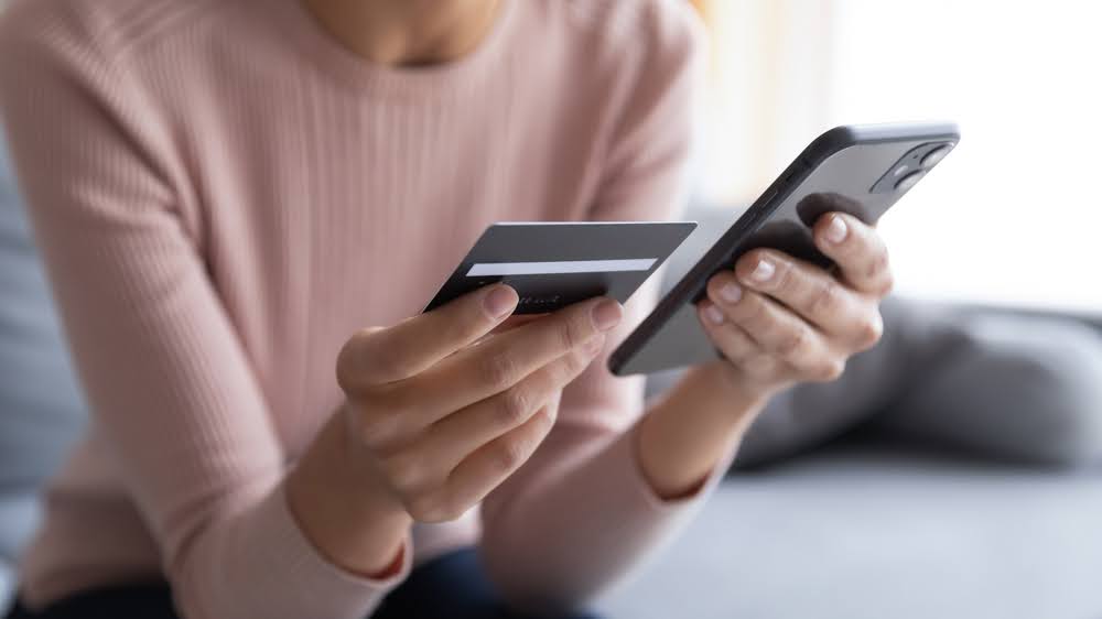 A businesswoman holding a credit card, working on financial management for her small business