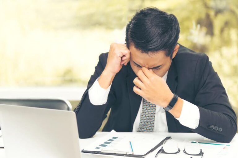 A businessman showing stress over ongoing cash flow problems.