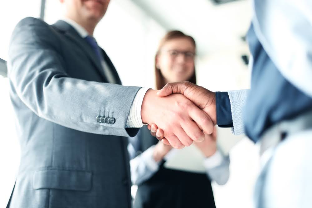 A financial expert shaking hands with a client after helping him successfully resolve cash flow problems.