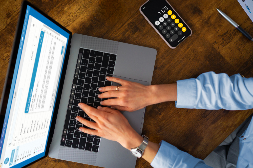 A close-up of an accountant working on a desktop computer in an office setting.