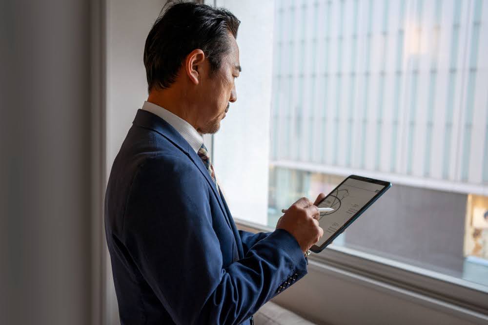 A company executive reviewing the end of Q3 report on a tablet.