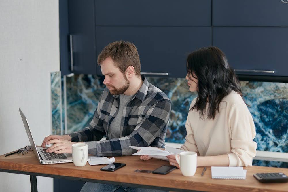 Business partners choosing a debt company among competing offers to resolve their debt issues.
