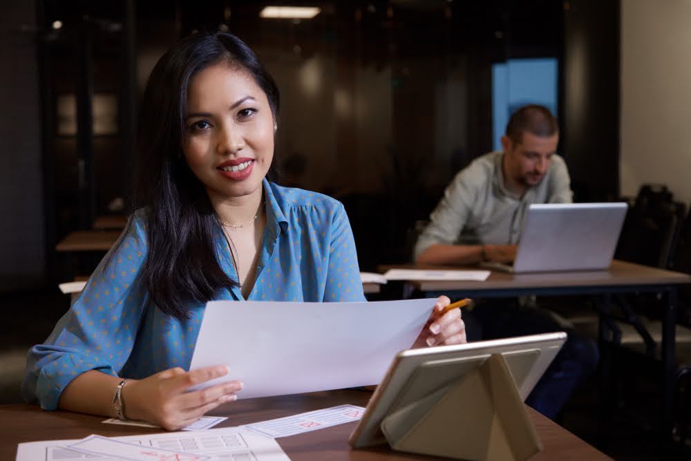 A professional bookkeeper sitting at her desk, working on financial statements.