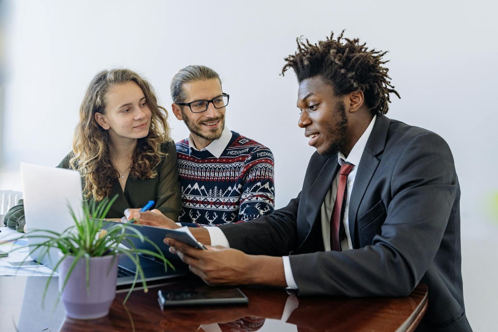 Two people working with their negotiator on debt settlement.