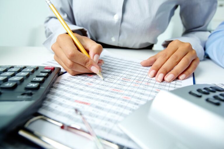 Woman reviewing financial documents as part of a weekly accounts payable system process.