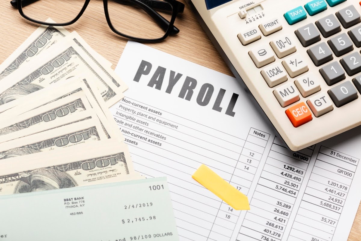 Financial documents, cash, and a calculator on the table.