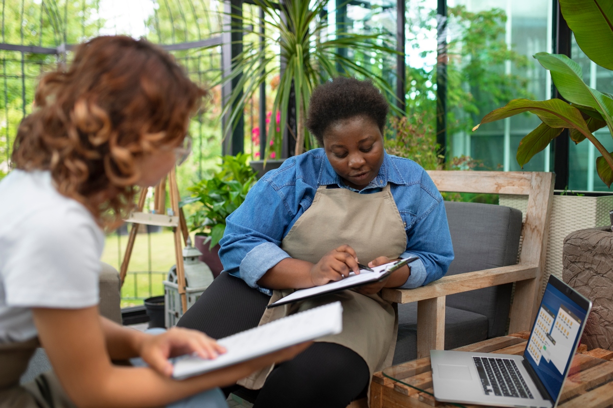 A financial advisor sitting with a flower shop owner and reviewing her finances.