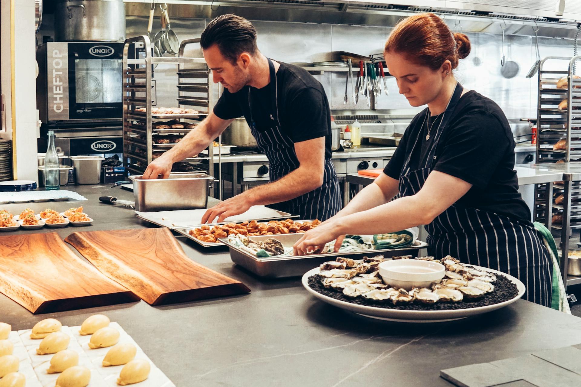 A man and a woman preparing food in the restaurant.