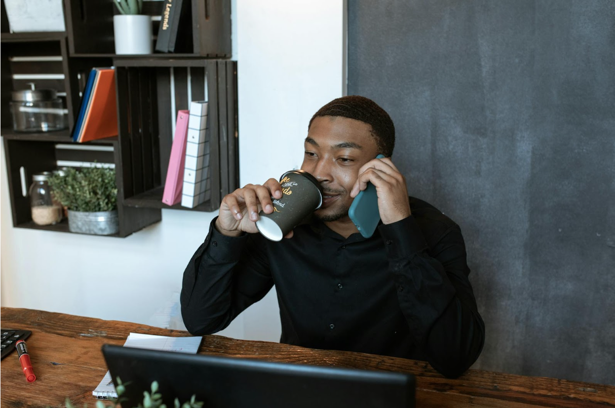 A small business owner in his office, drinking coffee.