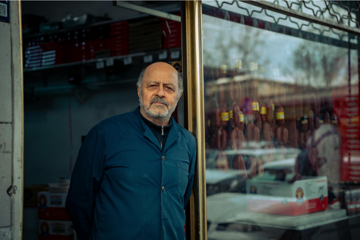 A business owner standing in front of his store.