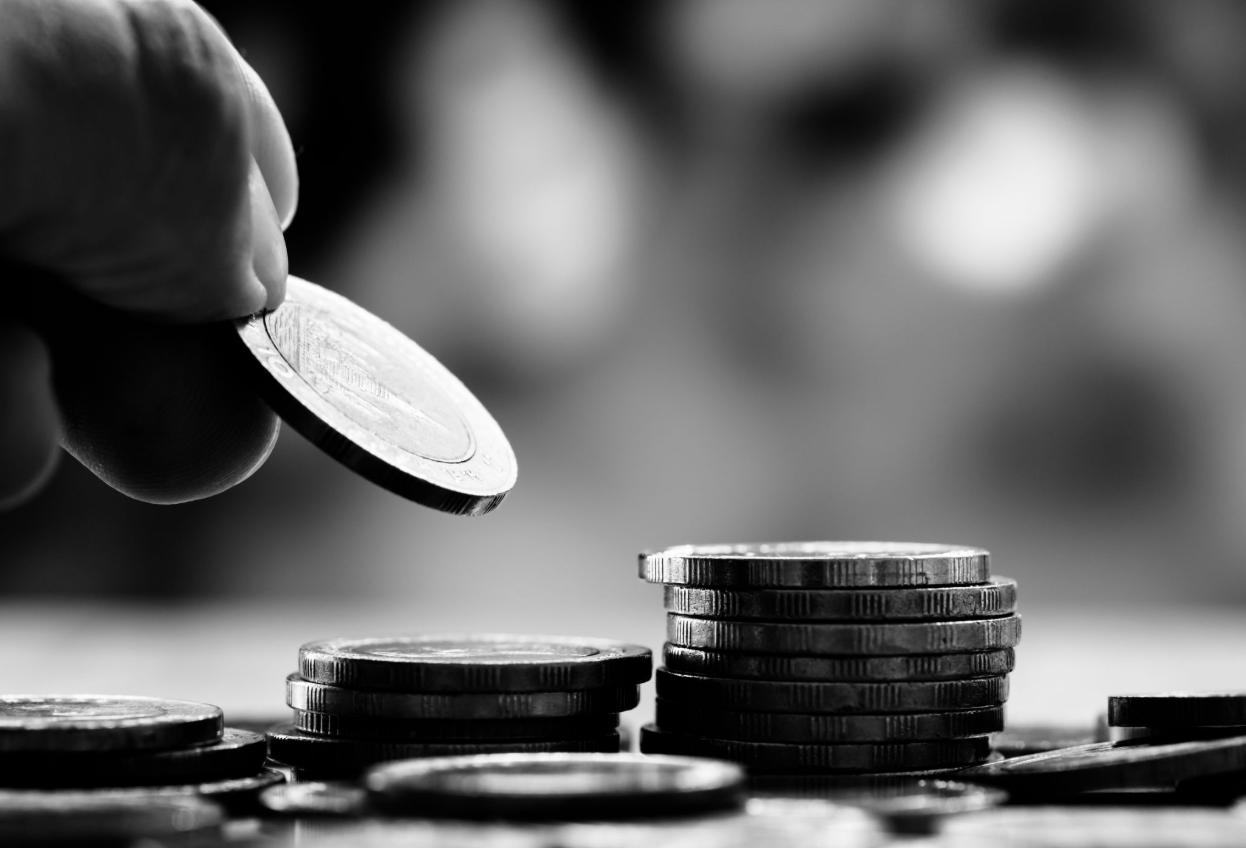 Person separating the coins on the table symbolizing financial clarity.