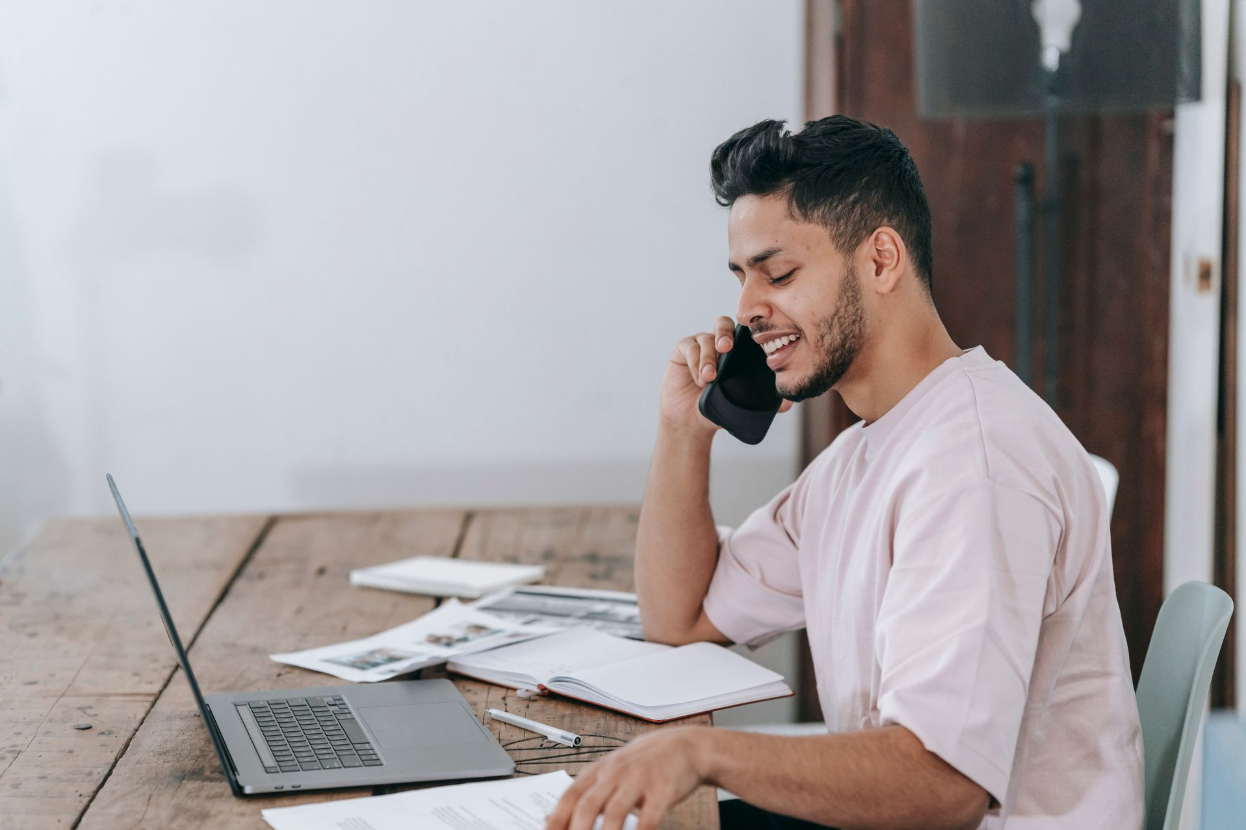 A businessman reading a profit and loss statement while talking on a phone.